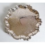 A Victorian silver salver with etched decoration and pie crust border on three claw and ball feet by