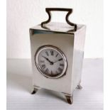 An Art Deco silver cased miniature clock with Roman numerals, swing handle on splayed feet by Hasset