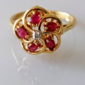A diamond and ruby-set cluster ring centering on an 8-cut diamond, 1.7mm diameter, surrounded by