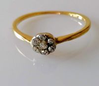 An Edwardian diamond flower ring with an old-cut diamond to centre, surrounded by six single-cut