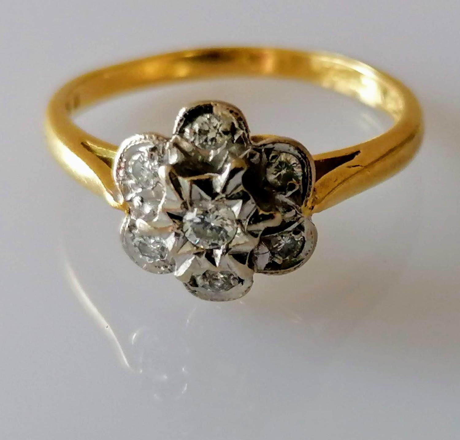 A diamond set cluster ring centering on a brilliant-cut diamond, 2.5mm diameter, surrounded by six