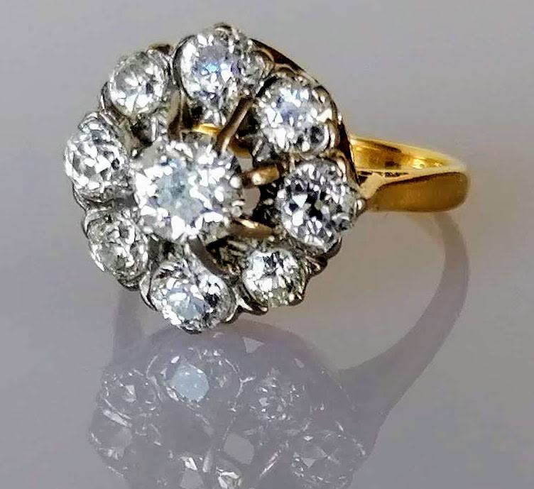 A diamond cluster ring on a claw-set yellow and white 18ct gold setting: the central old European-