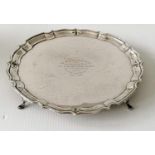 A George V silver salver with pie crust border on four hoof feet by Barker Brothers, Chester,