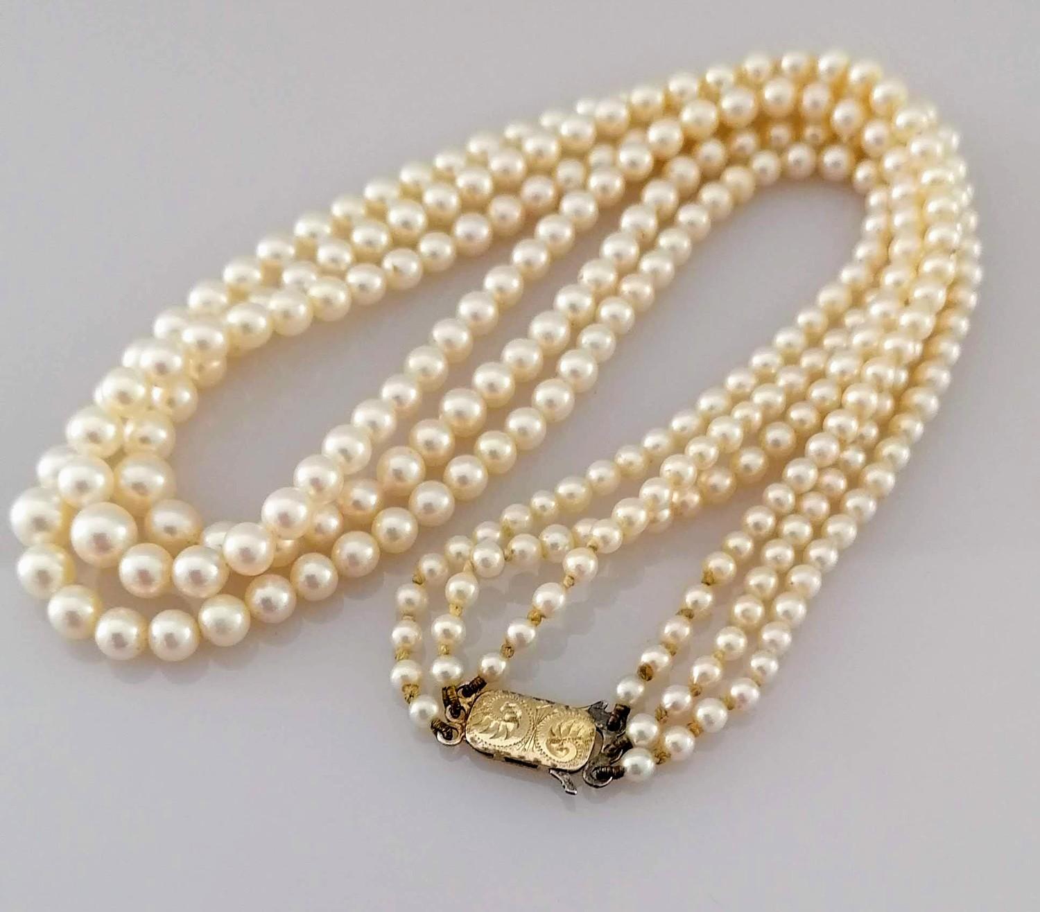 A mid-century three-strand graduated Akoya pearl necklet comprising ninety-one, ninety-five, and 103