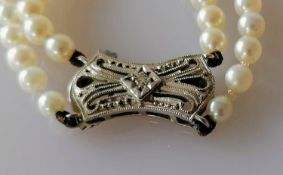 An Art Deco-style two-row necklet of ninety-eight/one hundred and eight graduated cultured pearls