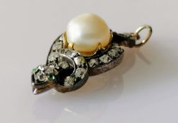 An Edwardian pearl and diamond pendant shaped as a serpent with peridot eyes, on white metal, 35 x