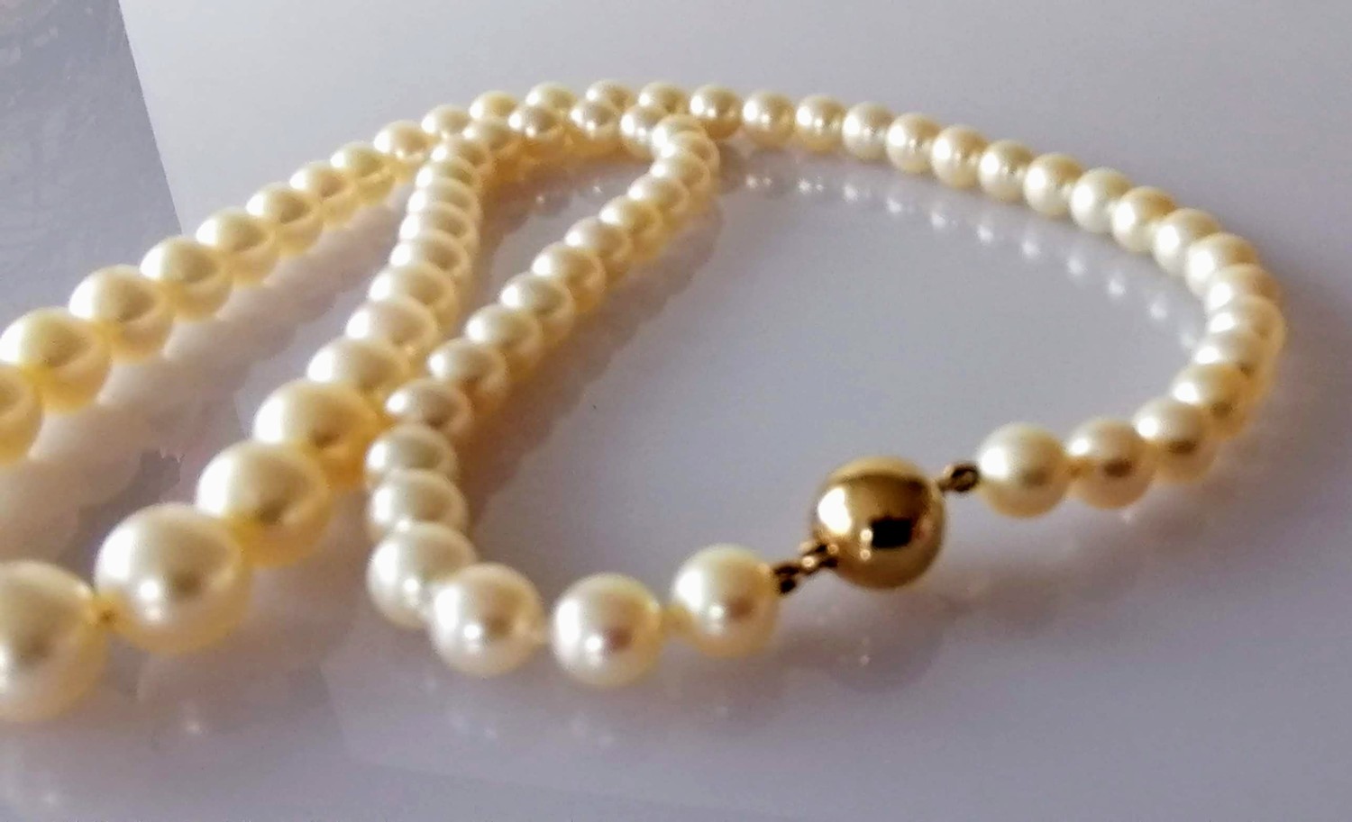 A mid-century single row of sixty-nine graduated Akoya cultured pearls measuring 6mm to 9.7mm with