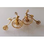 An artisan gold pair of cuff links in the form of penny farthings, unmarked, testing for 18ct, 9.8g