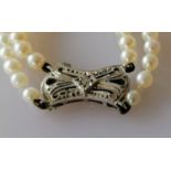 An Art Deco-style two-row necklet of ninety-eight/one hundred and eight graduated cultured pearls