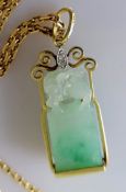 A carved jade pendant surmounted by a lion in a gold setting, 32mm x 12mm and chain, both hallmarked