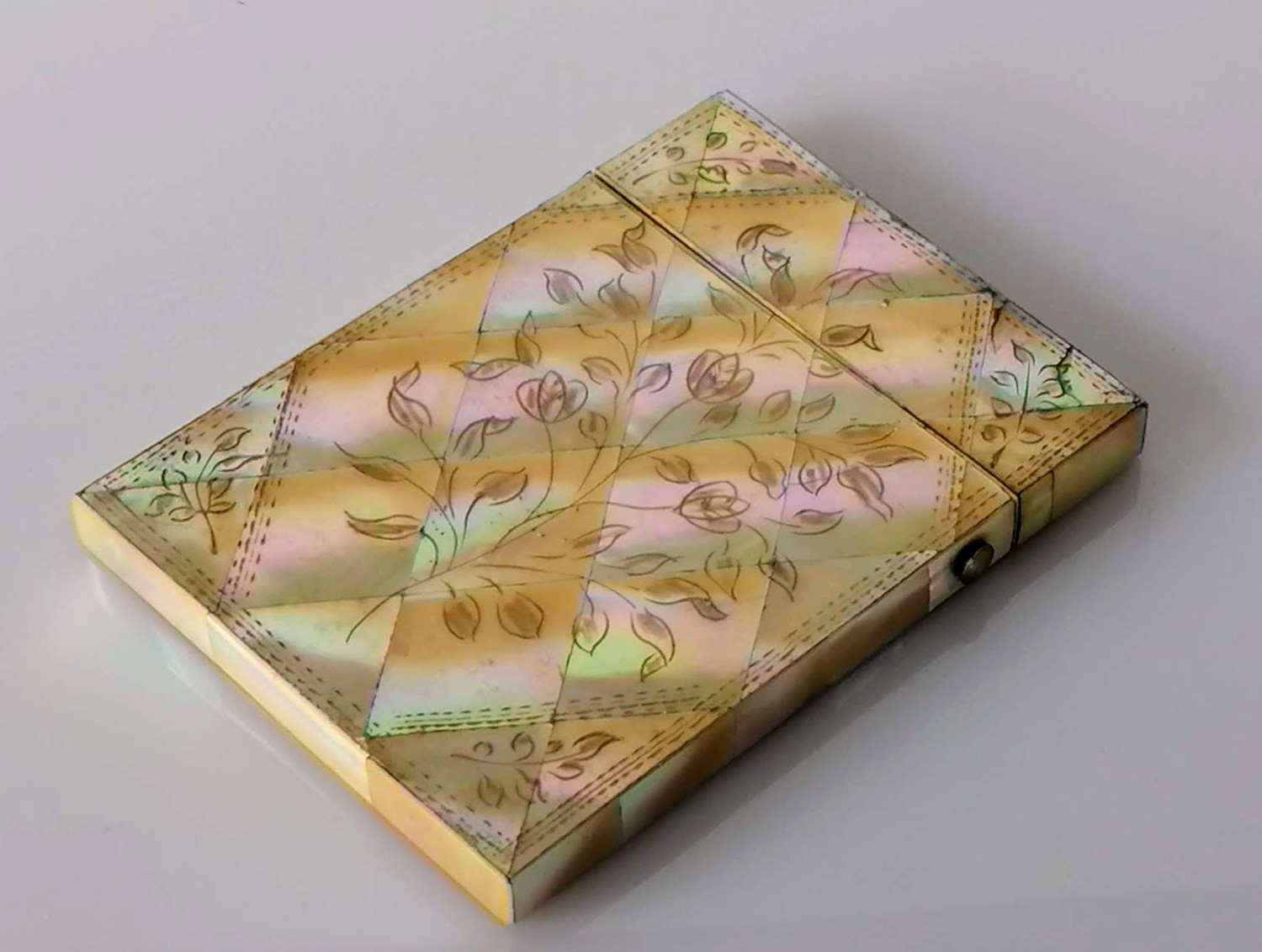 A mother-of-pearl oblong card case with hinged lid and floral decoration, 10 x 8 cm, in good