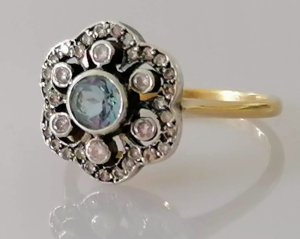 An Edwardian aquamarine and diamond flower ring on yellow gold, tests for 14ct, size Q, 4g