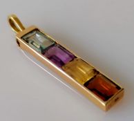 A four-stone baguette-cut multi-coloured channel-set stick pendant with loop in a yellow gold