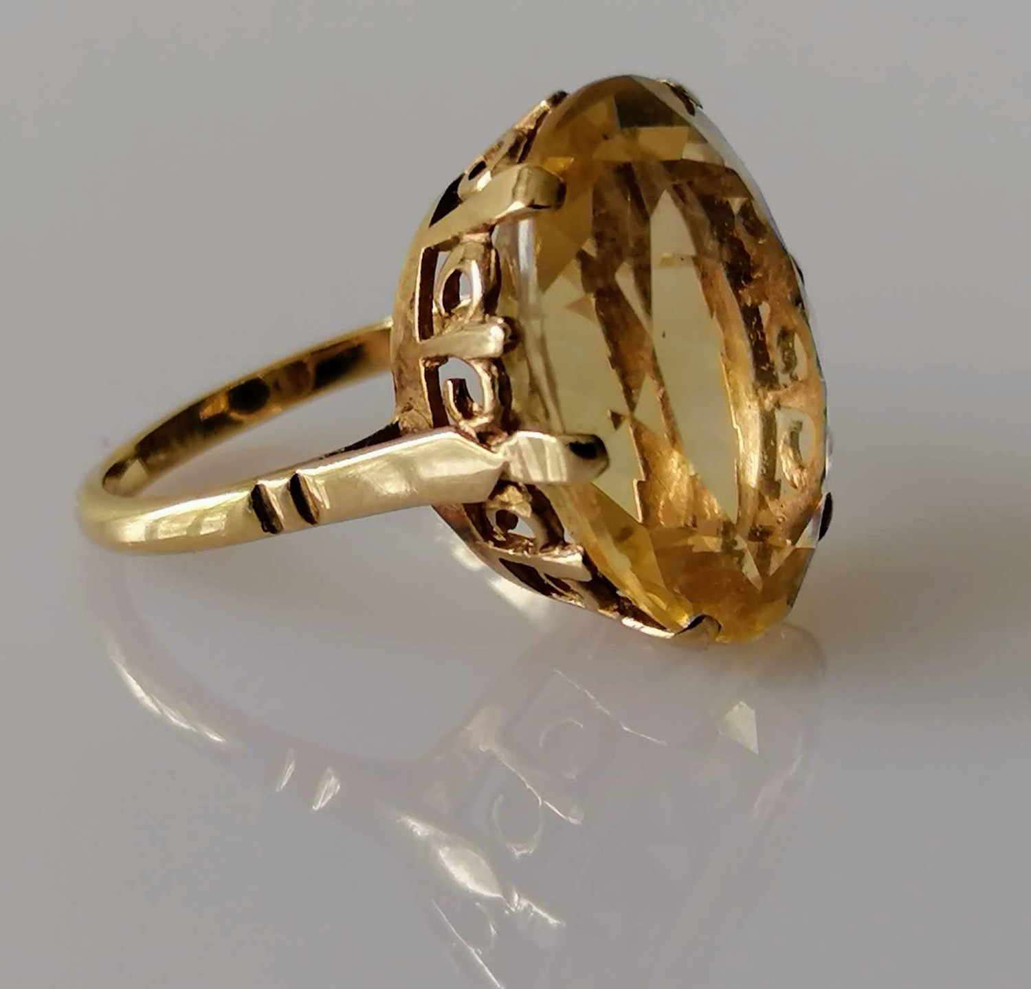 An oval faceted citrine dress ring on a gold basket setting, 20mm x 15mm, stamped 9ct, size P, 6.57g
