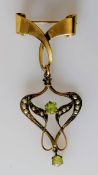 An Art Nouveau brooch with peridot and seed pearl decoration, 5 cm, stamped 9ct, 3.65g, two seed