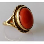 An oval cabochon coral dress ring on a yellow gold setting with rope-twist design, coral 15mm x