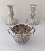 A pair of Victorian silver candlesticks with embossed rococo design and sconces, by Hilliard &