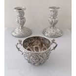 A pair of Victorian silver candlesticks with embossed rococo design and sconces, by Hilliard &