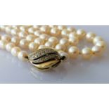 A mid-century single row of eighty-three cultured pearls, measuring from 5.62mm to 9.05mm on a white