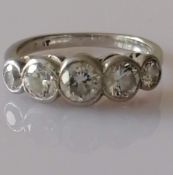 A five-stone graduated diamond platinum ring in a rubbed-over setting, largest stone approximately