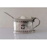 An Edwardian silver oval mustard pot with beaded borders, pierced body, bright-cut floral swags