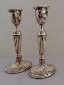 A pair of Victorian silver candlesticks with fluted decoration on oval spreading bases by Henry