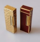A gold plated textured Dunhill Rollagas lighter, and another with red lacquer, both patent 24163 and