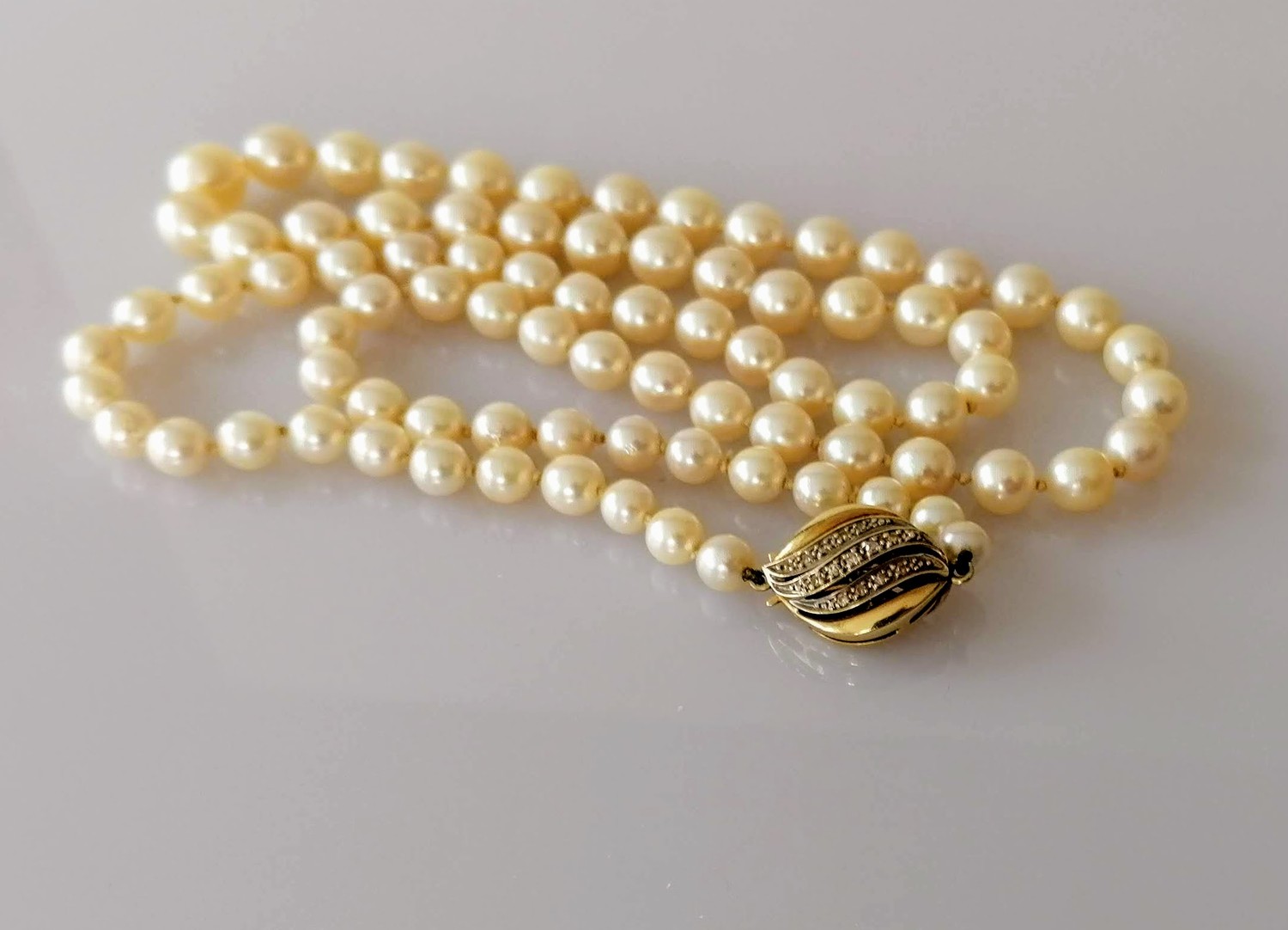 A mid-century single row of eighty-three cultured pearls, measuring from 5.62mm to 9.05mm on a white - Image 2 of 3