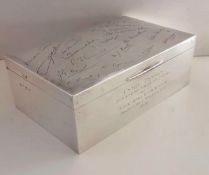 A larger Birmingham silver cigarette box of oblong form with presentation signatures and dedication,