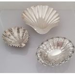 A Victorian larger silver scallop shell, another smaller with husks in relief, both on three ball