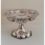 An Edwardian silver tazza with applied floral rim, pierced body on a flared, carved foot by George