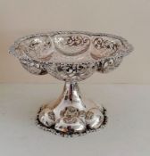 An Edwardian silver tazza with applied floral rim, pierced body on a flared, carved foot by George