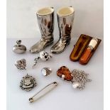 An assortment of silver bibelots to include a scent bottle, moonstone ring, articulated silver scull