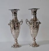 An Edwardian pair of urn-shape vases with inverted rims, embossed floral and fluted decoration,