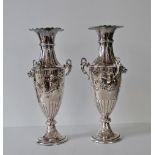 An Edwardian pair of urn-shape vases with inverted rims, embossed floral and fluted decoration,
