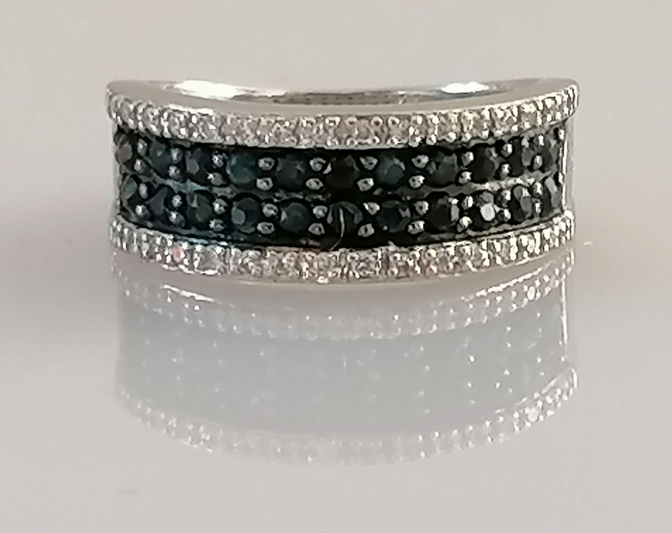 An 18ct white gold half-hoop eternity ring with pave-set white and black diamonds, size N1/2,