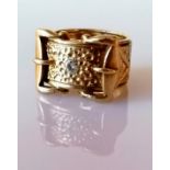 A large 9ct yellow gold buckle ring with brilliant-cut diamond, approximately 0.20 carats, size W,