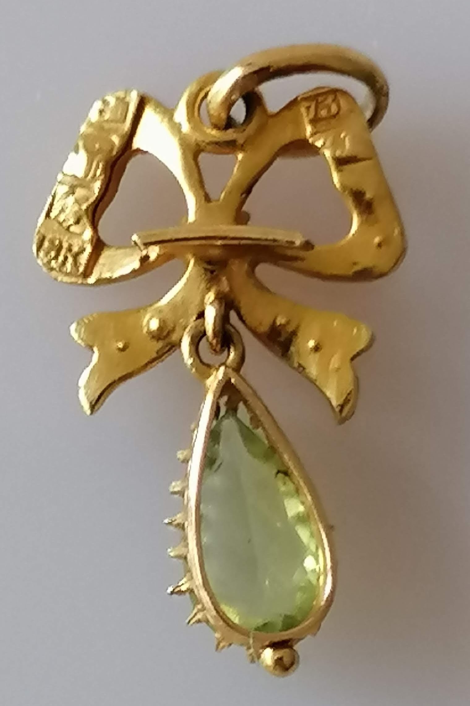 A Victorian gold ribbon pendant with seed pearl, garnet and peridot decoration, 36mm x 15mm, - Image 2 of 2