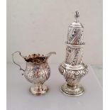 A George III silver cream jug with carved rim, embossed floral decoration, scroll handle on a raised