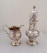 A George III silver cream jug with carved rim, embossed floral decoration, scroll handle on a raised