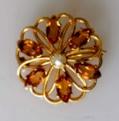 A circular citrine brooch in 9ct yellow gold centred with a pearl, 28mm diameter, hallmarked, 4.4g