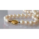 A mid-century necklet comprising fifty-four round/off-round cultured pearls, 7mm to 7.3mm