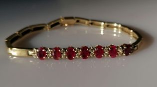 A yellow gold and ruby bracelet with diamond decoration, each ruby approximately 6mm x 4mm, 18 cm,