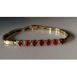 A yellow gold and ruby bracelet with diamond decoration, each ruby approximately 6mm x 4mm, 18 cm,