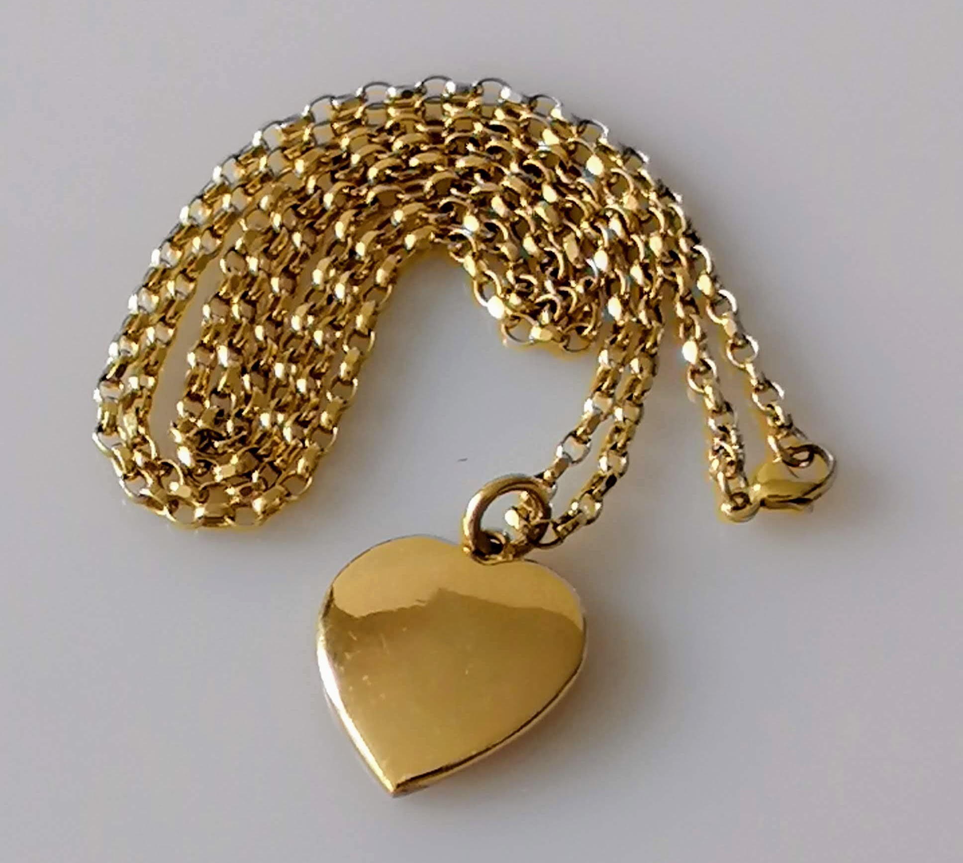 A gold heart-shape pendant, unmarked, tests for 9ct gold and chain, hallmarked 9ct, 58cm, 12.79g