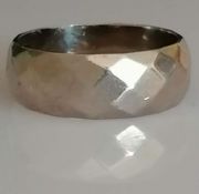 An 18ct white gold textured wedding band with faceted decoration, size Q, 7mm, hallmarked, 8.25g