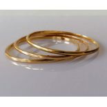 Three yellow gold bangles of plain form, unmarked, tests for 9ct, each 68mm, 40.5g