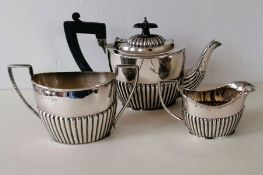 A late Victorian silver bachelor tea set with half-fluted decoration, teapot and jug