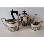 A late Victorian silver bachelor tea set with half-fluted decoration, teapot and jug