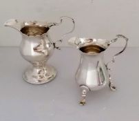A George III silver cream jug with carved rim, scroll handle on a spreading foot, maker's marks rubb